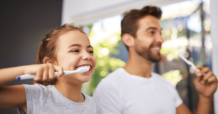 Daughter and father brushing their teeth using our dental tips during quarantine